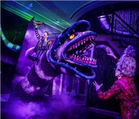 An actor riding a huge sandworm in purple lighting