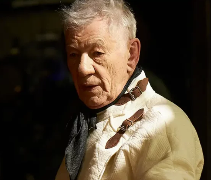 A close-up of actor Ian McKellen in a white suit