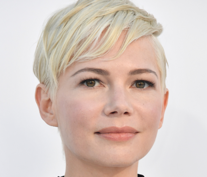 A close-up of Michelle Williams looking at the camera and smiling